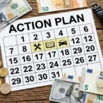A calendar with an "Action Plan", cash, and a watch on a wooden desk.